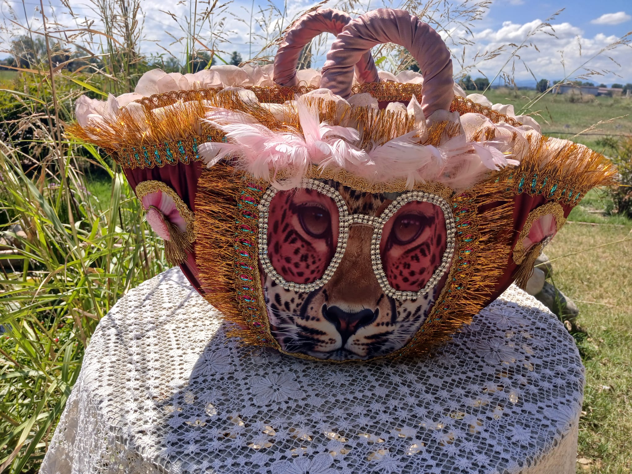 Straw bag with large decoration and pink feathers